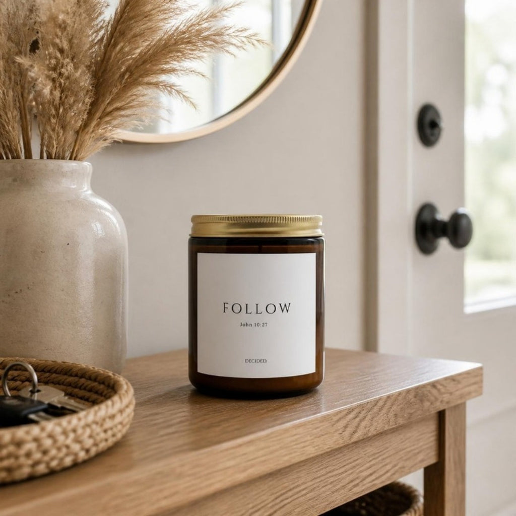 FOLLOW John 10:27 scripture candle styled in a cozy home setting - DECIDED.